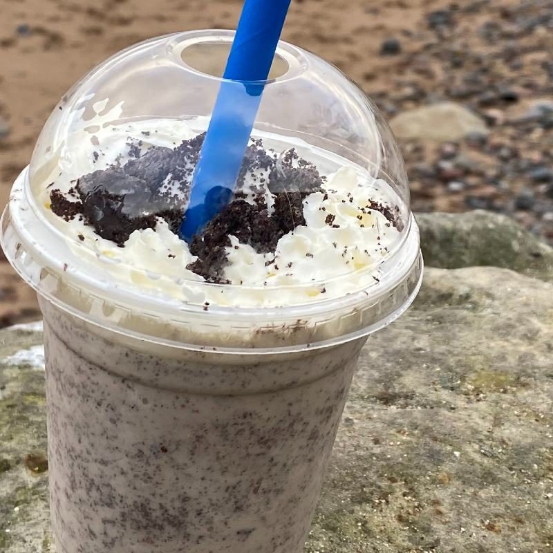 Photo of an oreo milkshake in a plastic cup