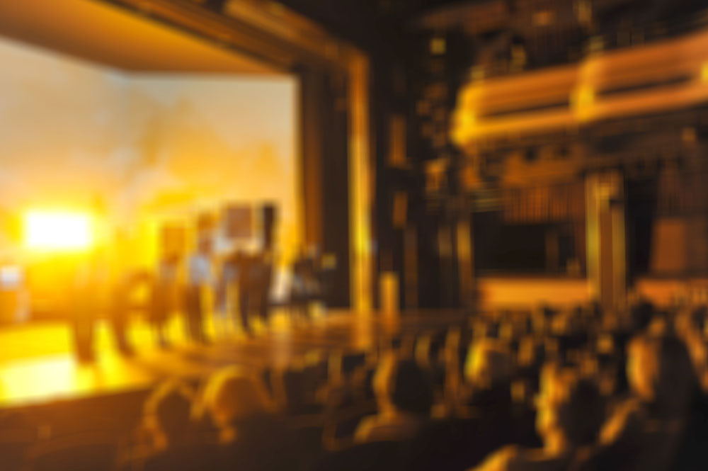 A blurry image of a theatre stage basked in golden light.